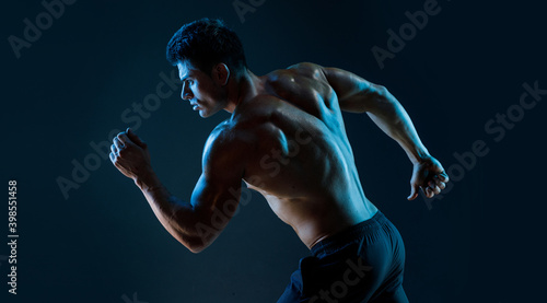 Wallpaper Mural Muscular model sports young man on dark background. Fashion portrait of strong brutal guy. Sexy torso. Male flexing his muscles. Torontodigital.ca