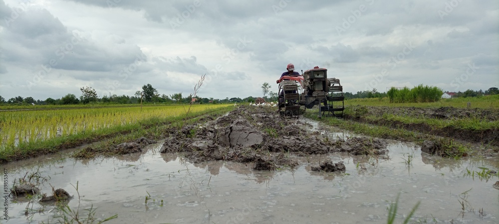 Fototapeta premium plowing the fields with a tractor in the morning