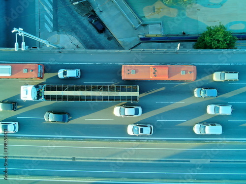 Vista aérea en plano cenital, de autos un camion y un micro,  detenidos en una autopista, durante el atardecer. 
 photo