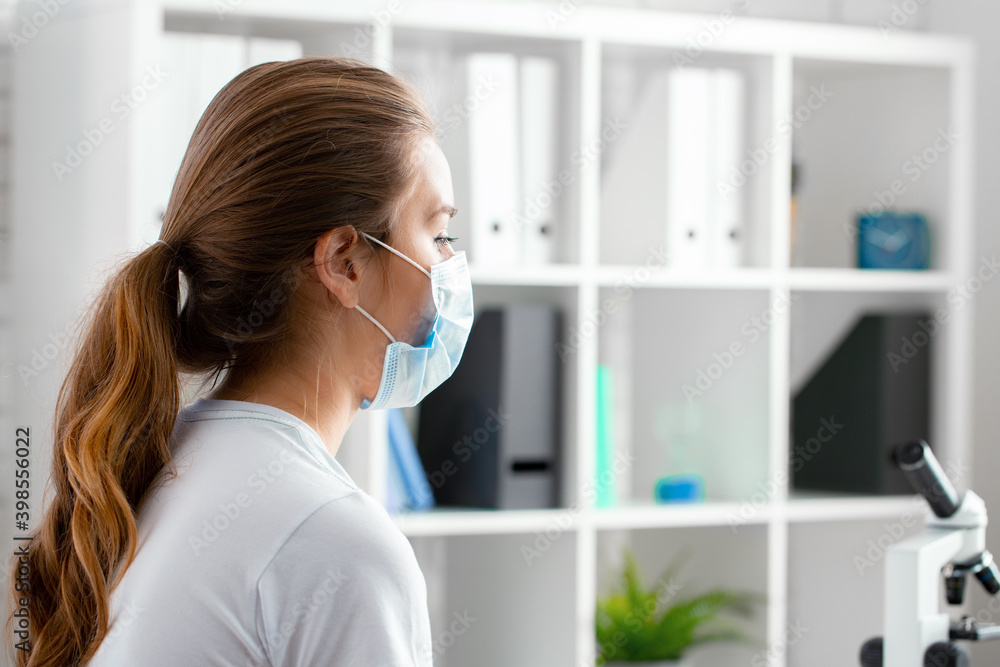 Woman patient in medical mask sitting in doctor's cabinet Woman patient in medical mask sitting in doctor's cabinet