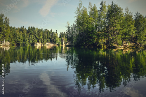 Górskie jezioro w lesie i odbicia w wodzie