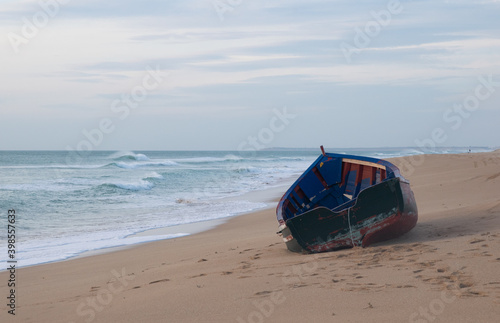 Solitary and abandoned immigrant dinghy patera boat at the Atlantic coast of south Spain photo