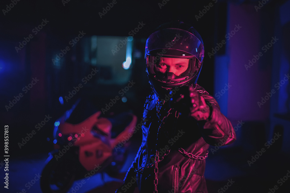 Motor biker is showing his fist with a chain at night street. Motor biker is showing his fist with a chain at night street.