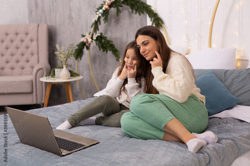 Fototapeta premium mother and daughter make fun of the camera via video link