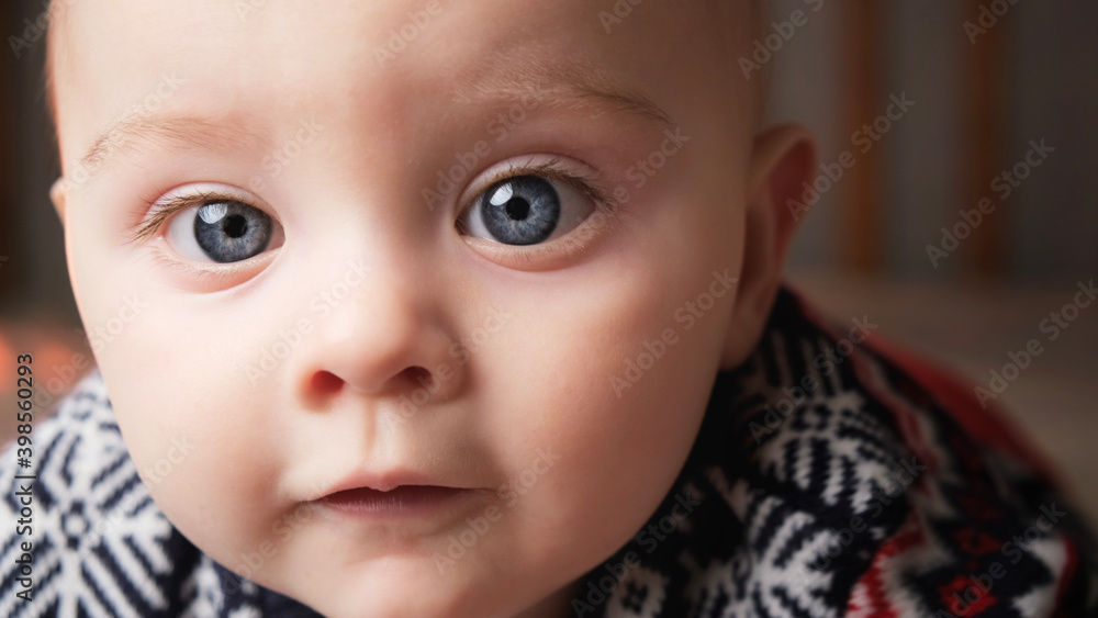 Closeup portrait of cute caucasian infant baby boy with blue eyes.