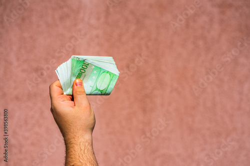 Hand holding showing euro money or giving money like bribe or tips.100 EURO banknotes EUR currency isolated. Concept of rich business people, saving or spending money. photo