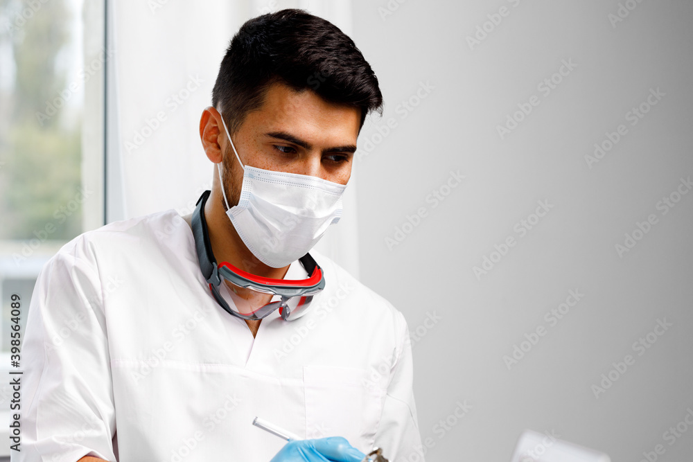Mixed race male doctor sitting at his working table in hospital Mixed race male doctor sitting at his working table in hospital