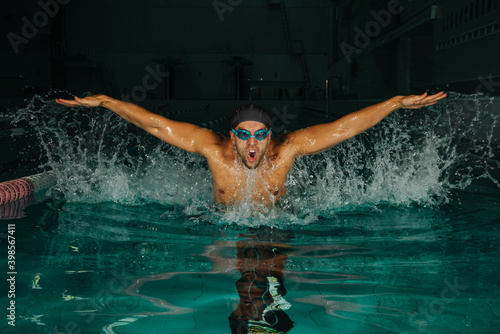 Swimmer in swimming pool with splashes