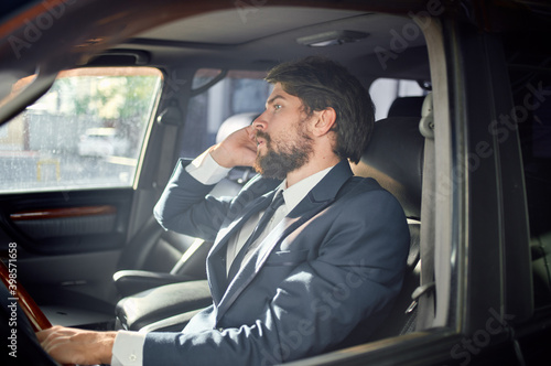 handsome man in suit driving a car trip talking on the phone finance