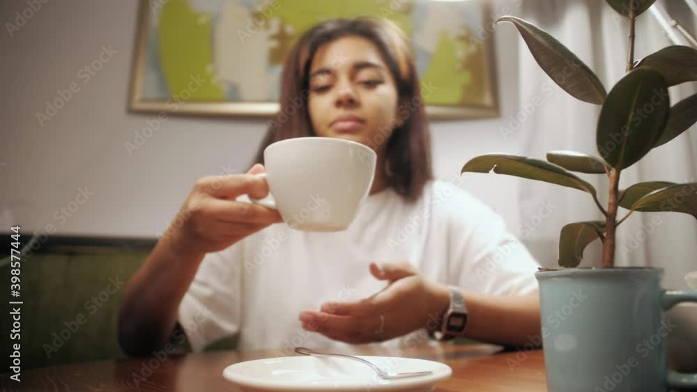 Young pretty girl sitting in coffee shop at table with cup of coffee on breakfast. Young pretty girl sitting in coffee shop at table with cup of coffee on breakfast.