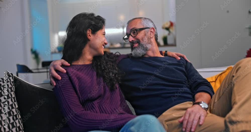 Senior father kissing daughter while sitting on sofa at home Senior father kissing daughter while sitting on sofa at home