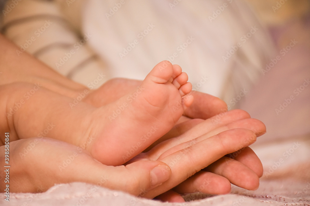 Close-up baby feet in mother hands. Tiny legs of newborn child. First days of life. Mom and her baby. Image of maternity and family. Close-up baby feet in mother hands. Tiny legs of newborn child. First days of life. Mom and her baby. Image of maternity and family.