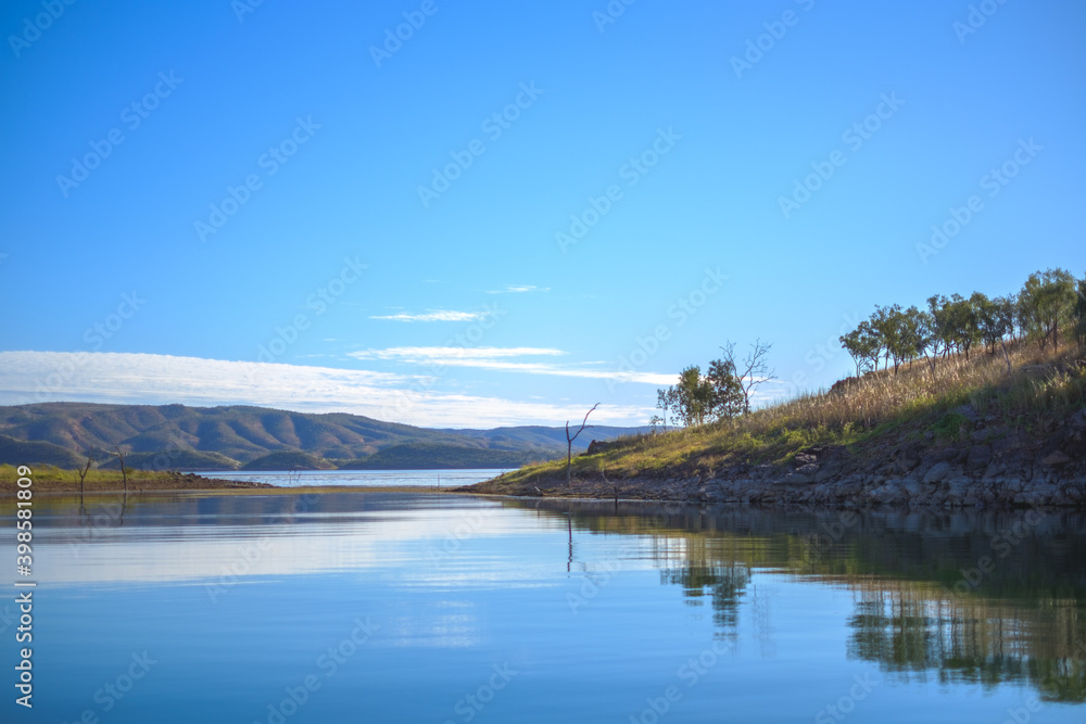 Obraz premium a body of water with hills in the background