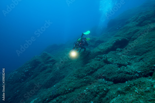Scuba diver in deep blue sea.