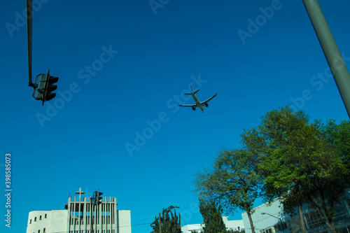 avion aterrizando desde lejos en la ciudad hacia el aereopuerto