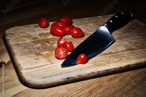 cherry tomatoes and knife on cutting board