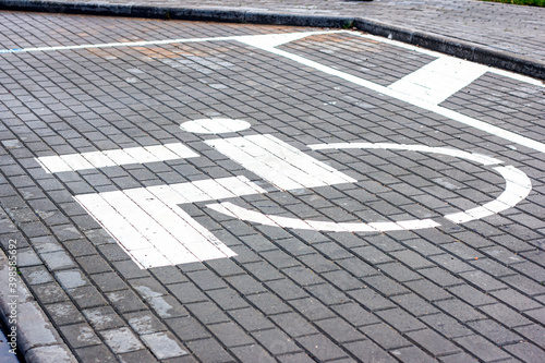 Parking lot for people with disabilities white road sign painted on asphalt in garage. © KatMoy