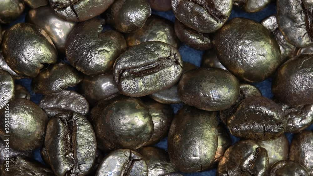 Golden coffee beans circling on rotating table Golden coffee beans circling on rotating table