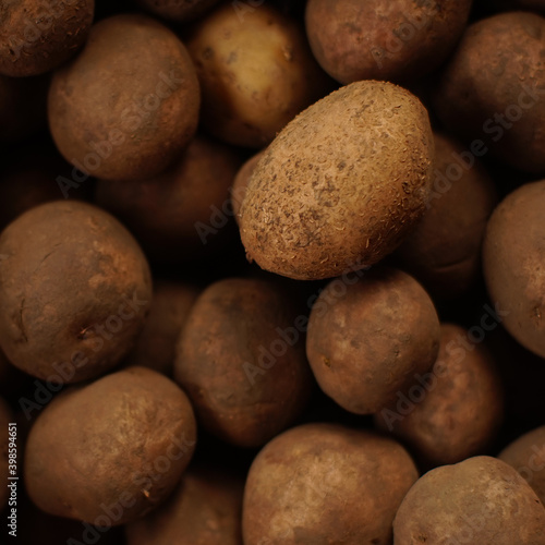 Background with dirty potatoes in a peel. Top view.