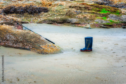 Boots and fishing pole on beach