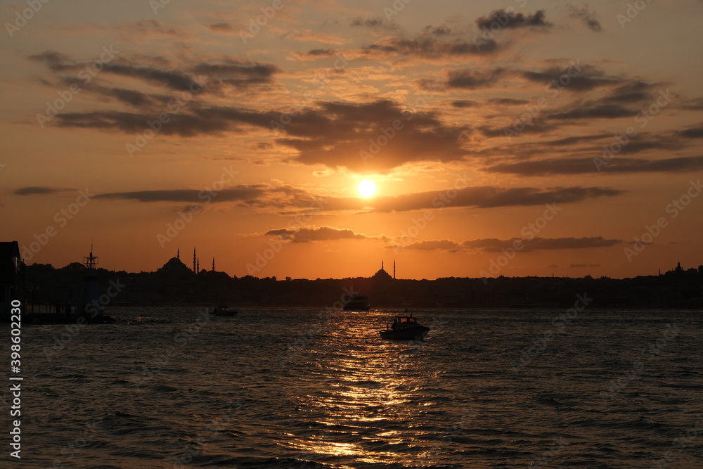 Fototapeta premium Lovely sunset and small boats with city background