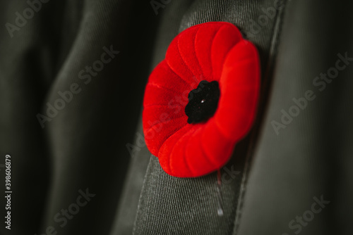 Фотография Close up of artificial poppy flower on coat lapel for Remembrance Day