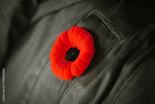 Close up of artificial poppy flower on coat lapel for Remembrance Day.