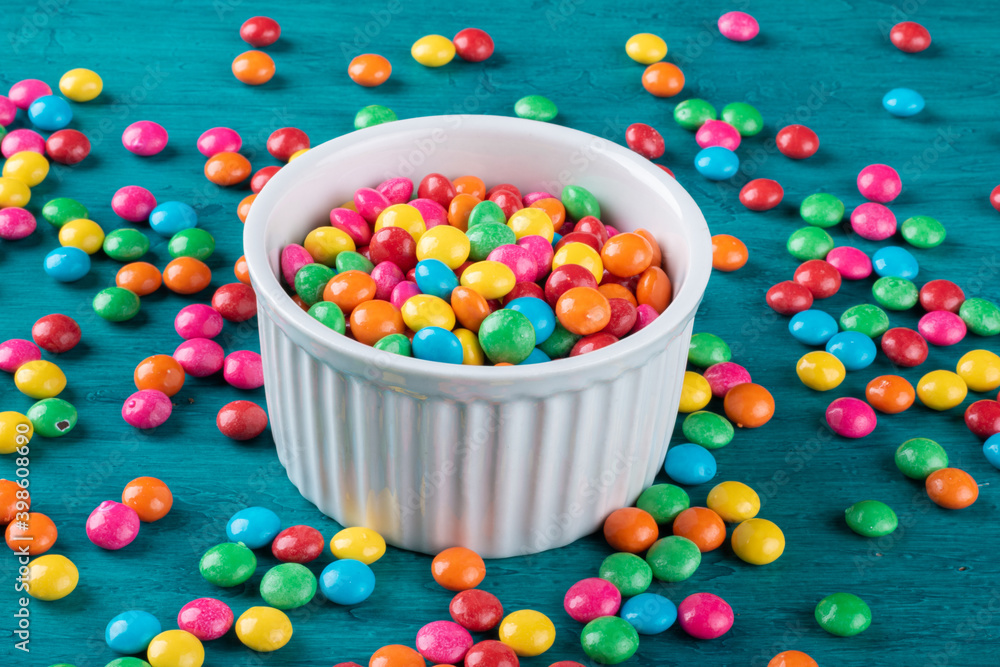 Colorful Confetti candy in bowl with blue background.