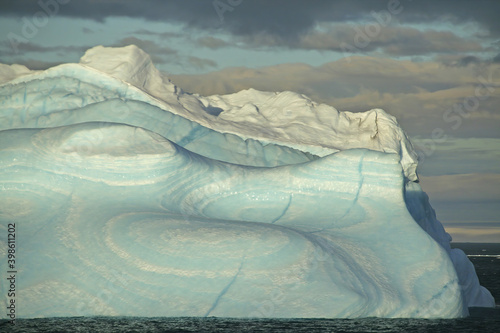 Iceberg with surrealistic blue swirls in Paradise harbor, Antarctica photo