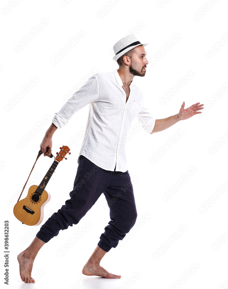 Naklejka premium Attractive young Caucasian male with ukulele isolated on white background.