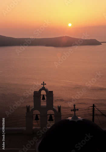View of Santorini blue domed church and Church bells under sunset in Santorini, Greece. 