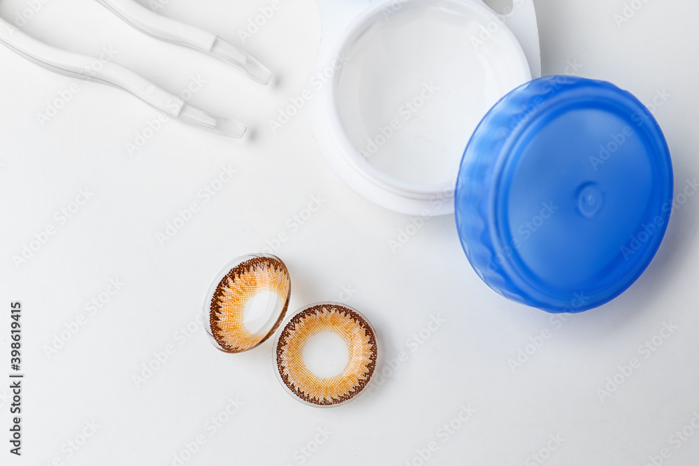 Contact lenses with container and tweezers on white background Contact lenses with container and tweezers on white background