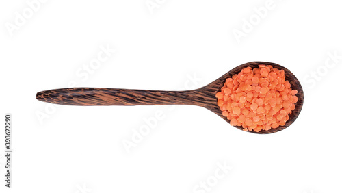 Red lentils in wood spoon on white background