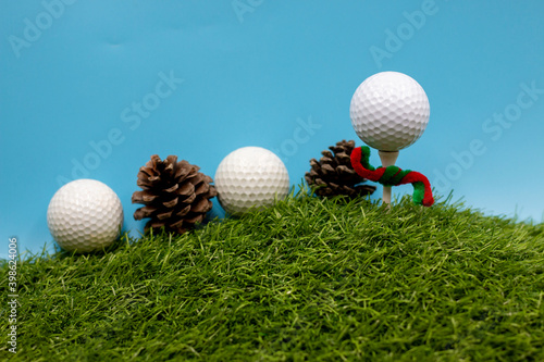 Golf ball with Christmas ribbon on blue sky background