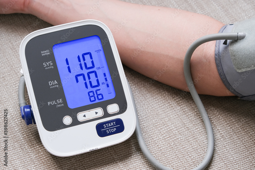 Man check blood pressure monitor and heart rate monitor with digital pressure gauge. Health care and Medical concept Man check blood pressure monitor and heart rate monitor with digital pressure gauge. Health care and Medical concept