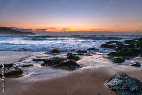 Sunrise seascape with light cloud  waves and rocks