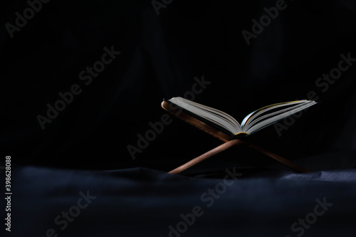 The Holy Quran in Mosque - Open to Read - Study the black background practices of Muslims around the world placed on wooden boards in low-light mosques.