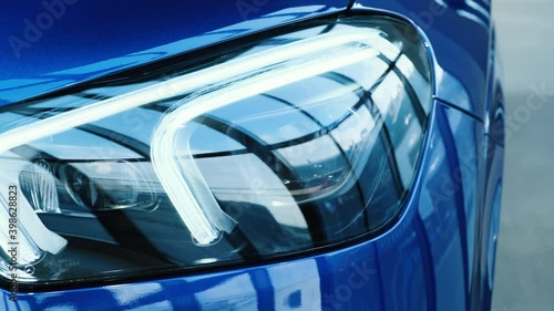 Close-up of the headlight of a new blue car in the showroom. Modern laser headlights. Led lights. Xenon. Bixenon. Front view photo