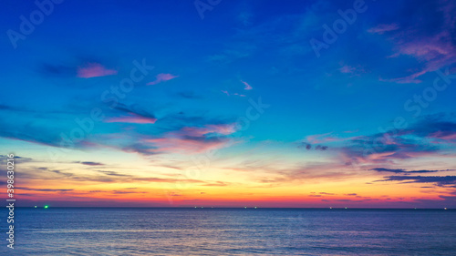 Beautiful sunset over the clam sea with cloud and sky background. Sunset over tropical beach. Nature summer  concept. Peak sunset over sea with yellow light reflect in cloud. © AKGK Studio