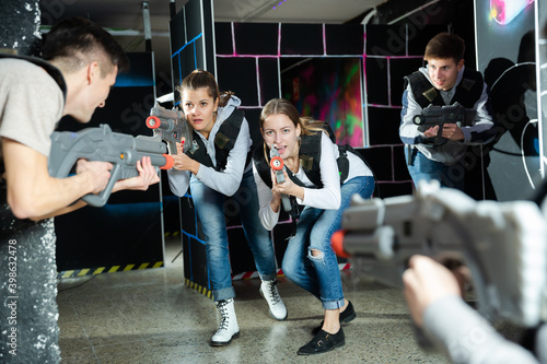 People in vests and with laser pistols playing emotionally laser. High quality photo