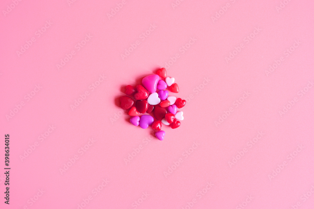 a heap of heart shaped glossy beads in different pink shades on a pink background a heap of heart shaped glossy beads in different pink shades on a pink background