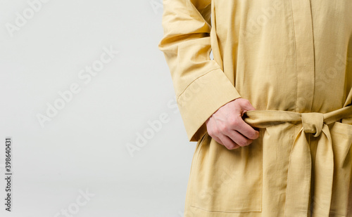  male hand close-up on a white background holds a belt on a dressing gown
