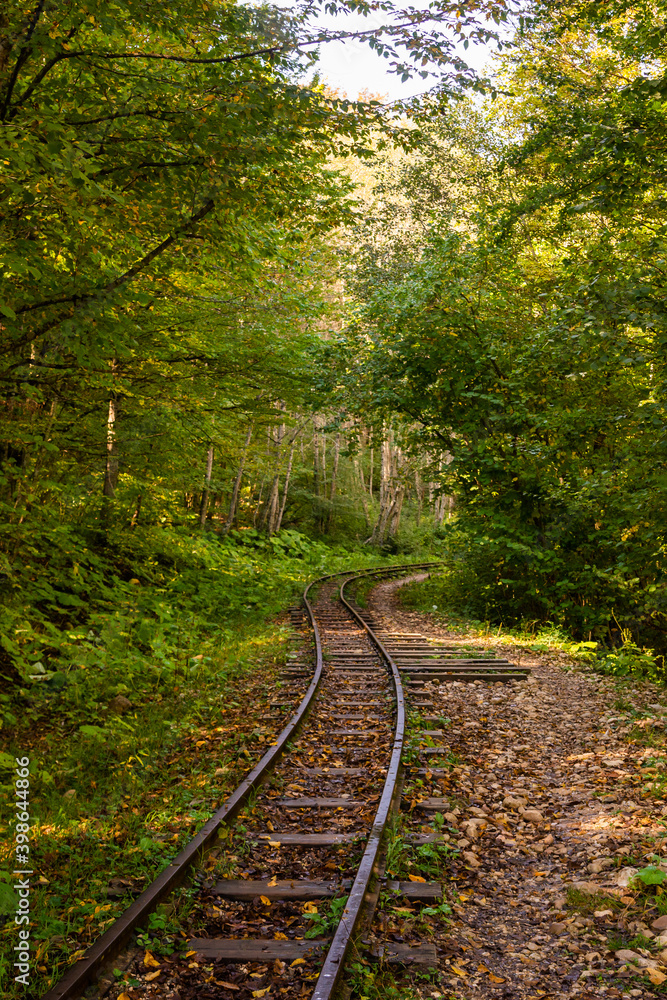 Abandoned railway in autumn mountain forest with foliar trees in Caucasus, Mezmay Abandoned railway in autumn mountain forest with foliar trees in Caucasus, Mezmay