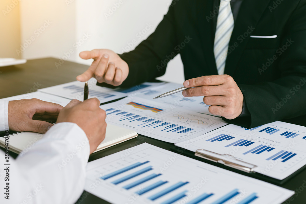 A group of professional business people sit on a meeting table in the