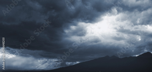 Dark blue dramatic sky with stormy clouds photo