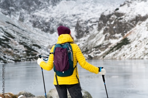 Woman backpacker resting on mountains. Walks with poles and admires beautiful views.