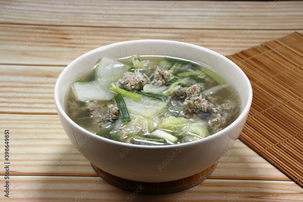Clear soup of cutting Chinese cabbage mixed with minced pork and fresh spring onion in the bowl. Famous traditional soup menu in Asia restaurant.