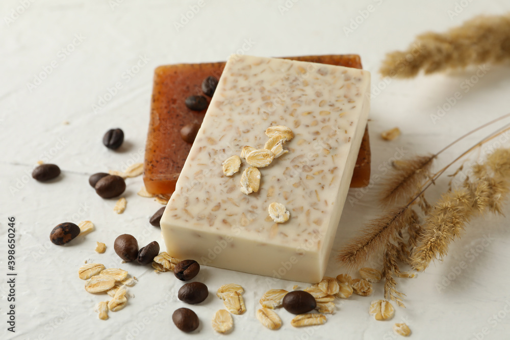 Natural soap, oat and coffee seeds on white table Natural soap, oat and coffee seeds on white table