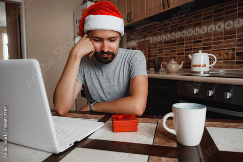 A hipster man with a red cup sitting at home at Christmas time.