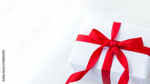 white kraft gift box with red ribbon bow on white background with place for text. copy space Valentine's Day card
